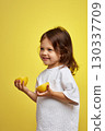 cute funny little child girl holding lemon on yellow background 130337709