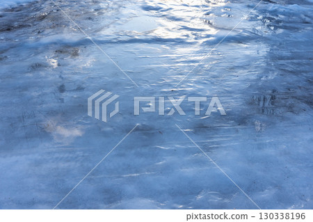 A detailed view of a reflective ice road surface, showcasing smooth textures 130338196