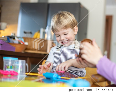 Blond boy sculpts from plasticine at home at the table. The idea and concept of the school, home education and developmental activities. 130338323