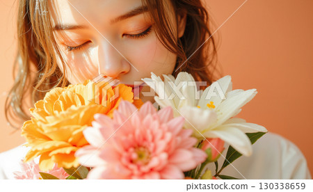 一位年輕女子手持一束鮮花、一份禮物或週年紀念禮物圖片 130338659