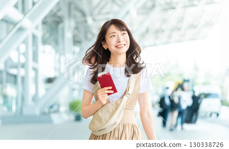 Traveling woman with passport at airport 130338726