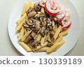 Fried mushrooms with pasta and tomatoes, top view 130339189