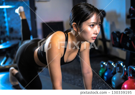 Cool woman training her buttocks with back kicks, muscle training, hip up, sports gym Cool woman training her buttocks with back kicks, muscle training, hip up, sports gym 130339195