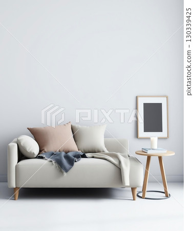 Minimalist interior design with a sofa, pillows, side table, and framed artwork in a bright room. 130339425