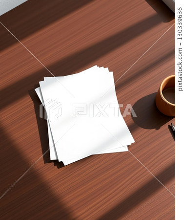 Close-up of white paper stack on a wooden desk with coffee cup and pen 130339636