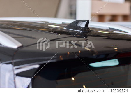 A detailed closeup view of the Car Roof Antenna positioned on a sleek, dark vehicle A detailed closeup view of the Car Roof Antenna positioned on a sleek, dark vehicle 130339774