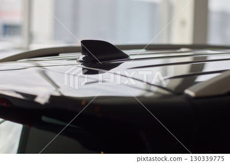 A detailed closeup view of the Car Roof Antenna positioned on a sleek, dark vehicle A detailed closeup view of the Car Roof Antenna positioned on a sleek, dark vehicle 130339775