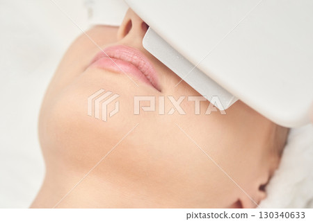 Caucasian female undergoing facial skin treatment with advanced beauty equipment Caucasian female undergoing facial skin treatment with advanced beauty equipment 130340633