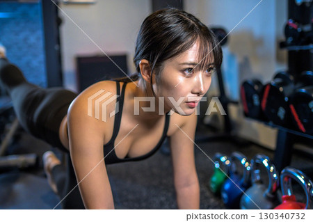 Cool woman training her buttocks with back kicks, muscle training, hip up, sports gym Cool woman training her buttocks with back kicks, muscle training, hip up, sports gym 130340732
