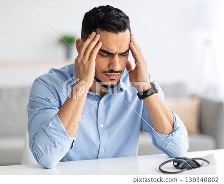 Young man touching head with painful expression, health problem and stress concept. High quality photo 130340802
