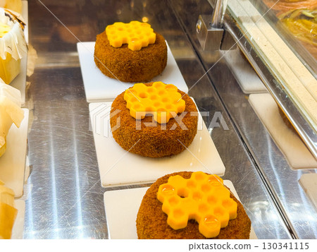 Round cakes decorated with honeycomb shaped topping. Confectionery, creativity, and sweetness inspired by nature. 130341115