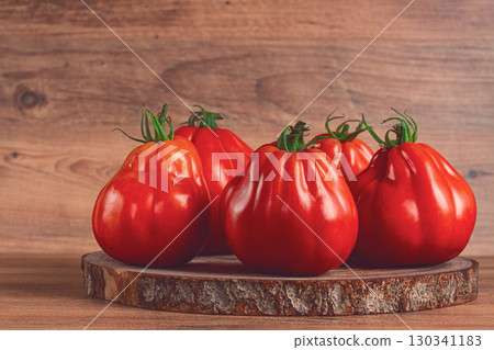 Khinkali tomatoes, on a wooden cutting board, wooden background, no people 130341183