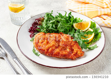 Milanese chicken, Crispy breaded chicken served, with fresh herbs, and lemon wedges, 130341210