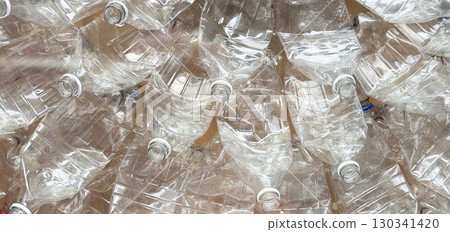 Crushed plastic bottles arranged in circular composition with golden center element. Ecology, recycling, and sustainability reflected through waste, consumption, and environmental art. Crushed plastic bottles arranged in circular composition with golden center element. Ecology, recycling, and sustainability reflected through waste, consumption, and environmental art. 130341420
