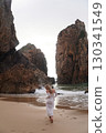 In Solitude by the Ocean A Woman Walking Alone Peacefully on the Beautiful Scenic Beachside 130341549