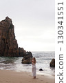 In Solitude by the Ocean A Woman Walking Alone Peacefully on the Beautiful Scenic Beachside 130341551