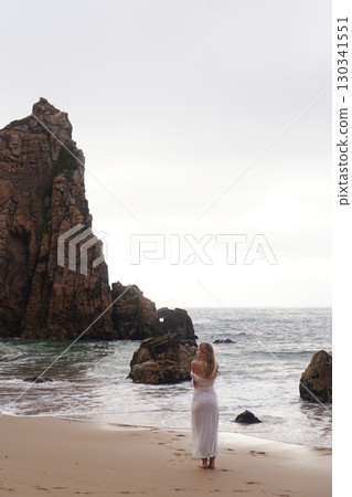 In Solitude by the Ocean A Woman Walking Alone Peacefully on the Beautiful Scenic Beachside In Solitude by the Ocean A Woman Walking Alone Peacefully on the Beautiful Scenic Beachside 130341551