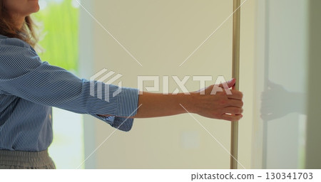 Woman opens refrigerator door and takes bottle of milk in kitchen at home. Woman opens refrigerator door and takes bottle of milk in kitchen at home. 130341703