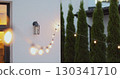 String lights hanging on line on outside house in backyard. Garden decoration. Party camping. 130341710