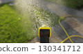 Man spraying green grass lawn with sprayer. Gardening, waters, growing and plants care. 130341712