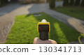 Man spraying green grass lawn with sprayer. Gardening, waters, growing and plants care. 130341713