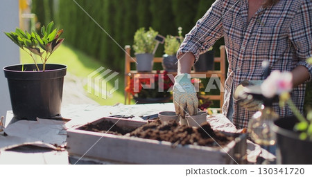 Preparation for transplanting a houseplant using extended clay, soil, shovel, rake and flowerpot. Home gardening. Hobbies and leisure concept. Preparation for transplanting a houseplant using extended clay, soil, shovel, rake and flowerpot. Home gardening. Hobbies and leisure concept. 130341720