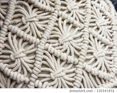 Closeup of macrame pattern with woven ropes. Handmade textile craft, bohemian decor and creative fiber art. Closeup of macrame pattern with woven ropes. Handmade textile craft, bohemian decor and creative fiber art. 130341858