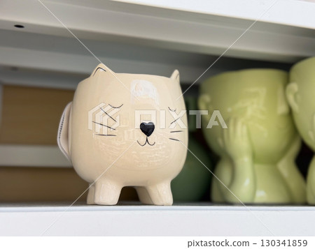 Ceramic flower pot in the shape of a cat. Decorative planter, cute design and creative home gardening accessory. 130341859