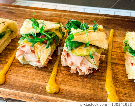 Closeup of sandwich with ham and vegetables. Fresh nutrition, flavor, and lifestyle food choice in modern dining. 130341958