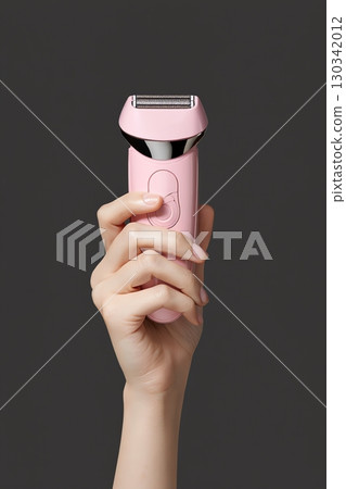 Pink personal grooming device held by a hand, modern electric beauty tool isolated 130342012