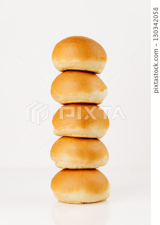 Stack of fresh round burger buns isolated on white background, front view, vertical composition 130342058