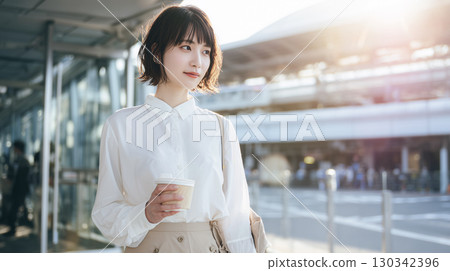 晚上，一位年輕女子在辦公區喝咖啡 130342396