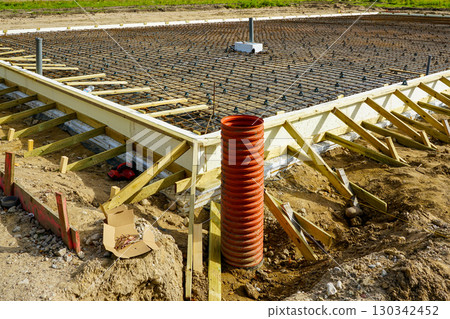 Reinforced concrete foundation construction with steel mesh and drainage pipe installation Reinforced concrete foundation construction with steel mesh and drainage pipe installation 130342452