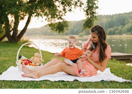 Baby Laughing With Mom By The Lake 130342698