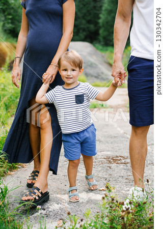 Smiling Child Holding Hands With Parents Outdoors 130342704