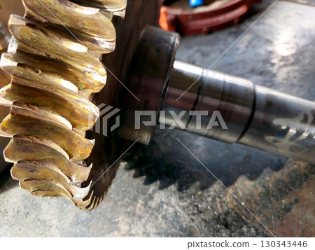 Bronze Worm Gear Wheel Resting on a Metal Surface in an Industrial Workshop Setting Bronze Worm Gear Wheel Resting on a Metal Surface in an Industrial Workshop Setting 130343446