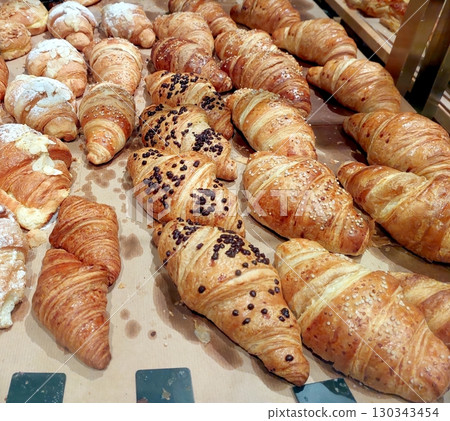 Freshly Baked Croissants Cooling on a Baking Sheet in a Warm Bakery Setting 130343454