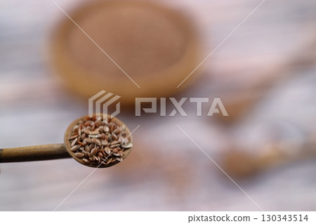 Flax seeds. Flaxseed powder in a wooden spoon. Standing on a Wooden background. Flax seeds. Flaxseed powder in a wooden spoon. Standing on a Wooden background. 130343514