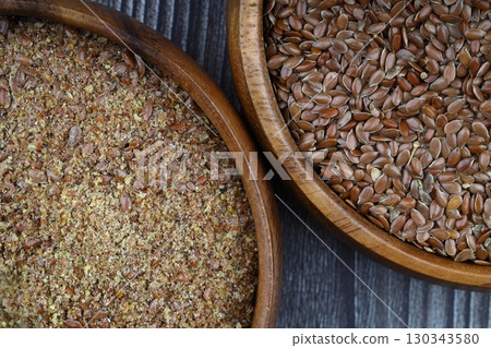 Flax seeds. Flaxseed powder in a wooden spoon. Standing on a Wooden background. 130343580