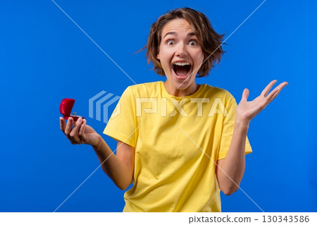 Pretty woman got jewelry box with proposal diamond ring on blue background 130343586