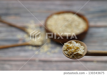 Breakfast cereals in wooden spoon. Healthy muesli with oat flakes, nuts and raisins isolated on wooden background. Selective Focus. Breakfast cereals in wooden spoon. Healthy muesli with oat flakes, nuts and raisins isolated on wooden background. Selective Focus. 130343675