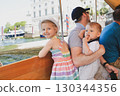 Father and children on a boat on Lake Maggiore sailing to the island of Isola Bella 130344356