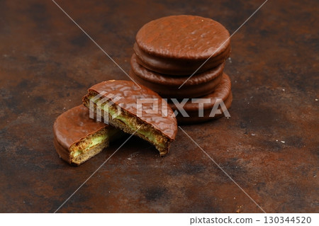 Delicious choco pies on wooden table, closeup. Space for text Delicious choco pies on wooden table, closeup. Space for text 130344520