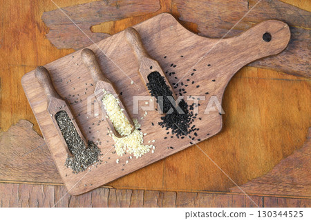 Wooden scoops with chia, black cumin and white sesame seeds close-up. Selective Focus. 130344525