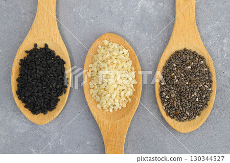 Wooden scoops with chia, black cumin and white sesame seeds close-up. Selective Focus. 130344527