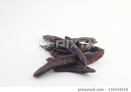 Carob on white background. Organic carob pods with seeds Carob on white background. Organic carob pods with seeds 130344558