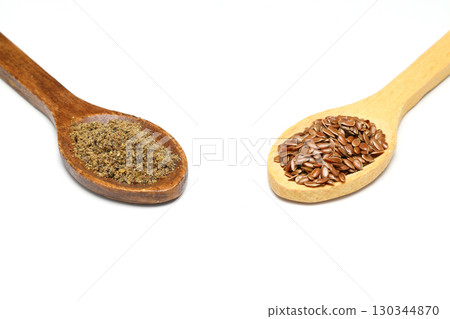Flax seeds. Flaxseed powder in a wooden spoon. Standing on a white background. Flax seeds. Flaxseed powder in a wooden spoon. Standing on a white background. 130344870