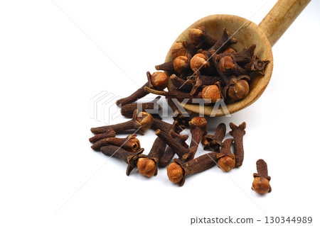 Dry cloves in wooden scoop isolated on white background with clipping path. Top view. Flat lay. selective focus. Dry cloves in wooden scoop isolated on white background with clipping path. Top view. Flat lay. selective focus. 130344989