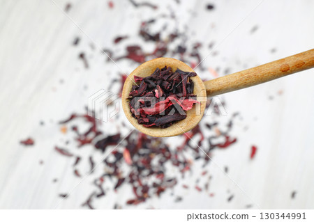 Karkade tea. Hibiscus tea leaves in wooden spoon isolated on white background. File contains clipping path. Top view. 130344991