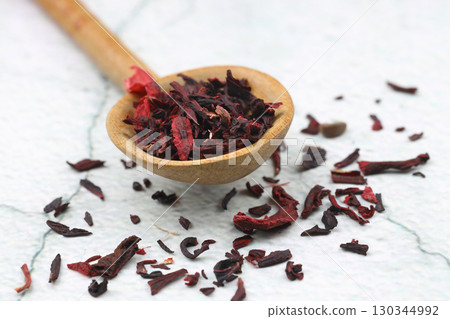 Karkade tea. Hibiscus tea leaves in wooden spoon isolated on white background. File contains clipping path. Top view. Karkade tea. Hibiscus tea leaves in wooden spoon isolated on white background. File contains clipping path. Top view. 130344992